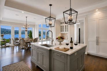Modern kitchen with island and lake view dining area.