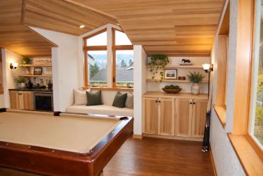 Cozy game room with pool table and window seating.