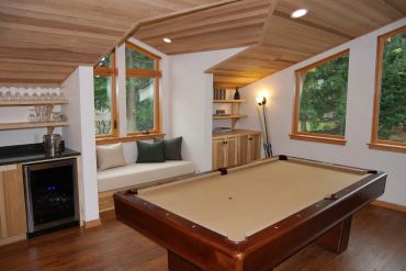Cozy game room with a billiard table and window seat.