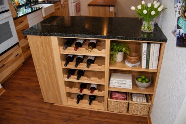Wooden kitchen island with wine rack and shelves.