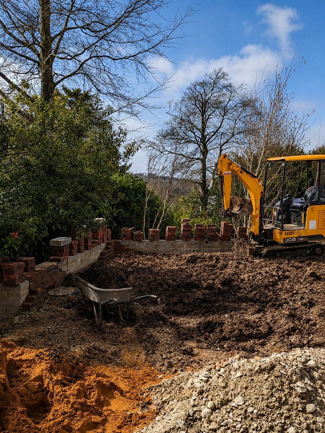 Excavator working in a garden under construction.