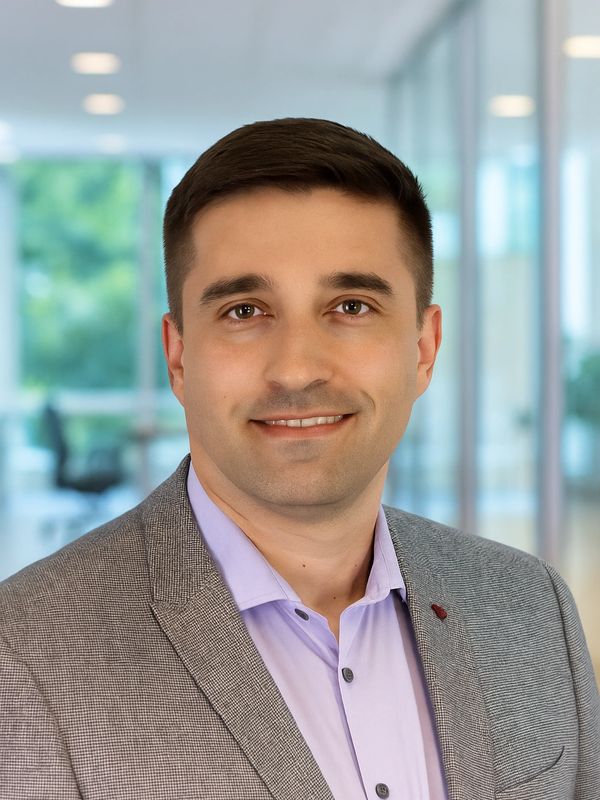 Professional man smiling in an office setting.