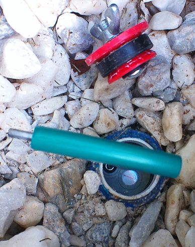 Disassembled small mechanical parts on rocky ground.