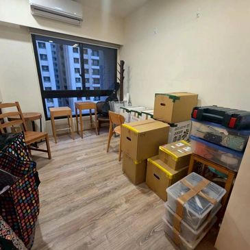 Room with packed boxes and stacked storage containers by the wall.