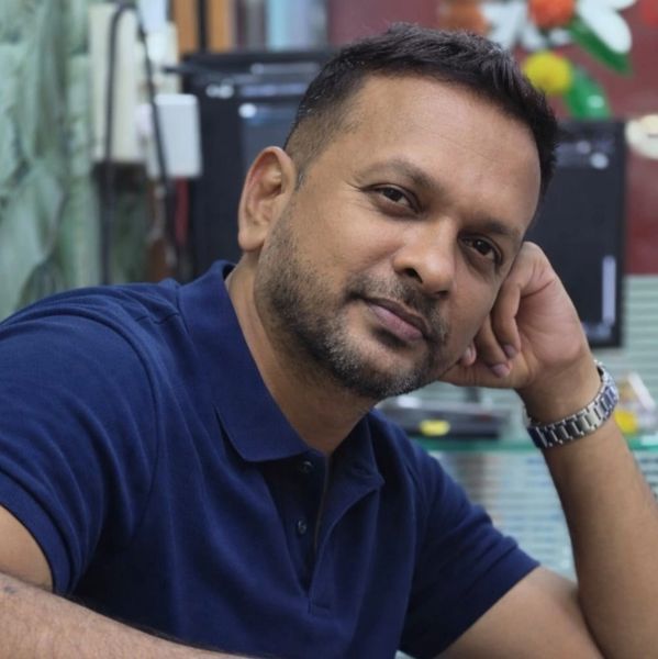 Man in blue polo shirt resting his head on his hand.