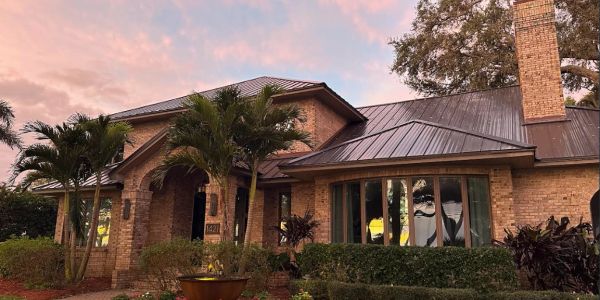 Brick house with lush landscaping at sunset.