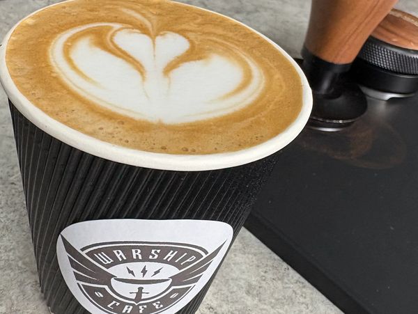 latte art in black to-go cup