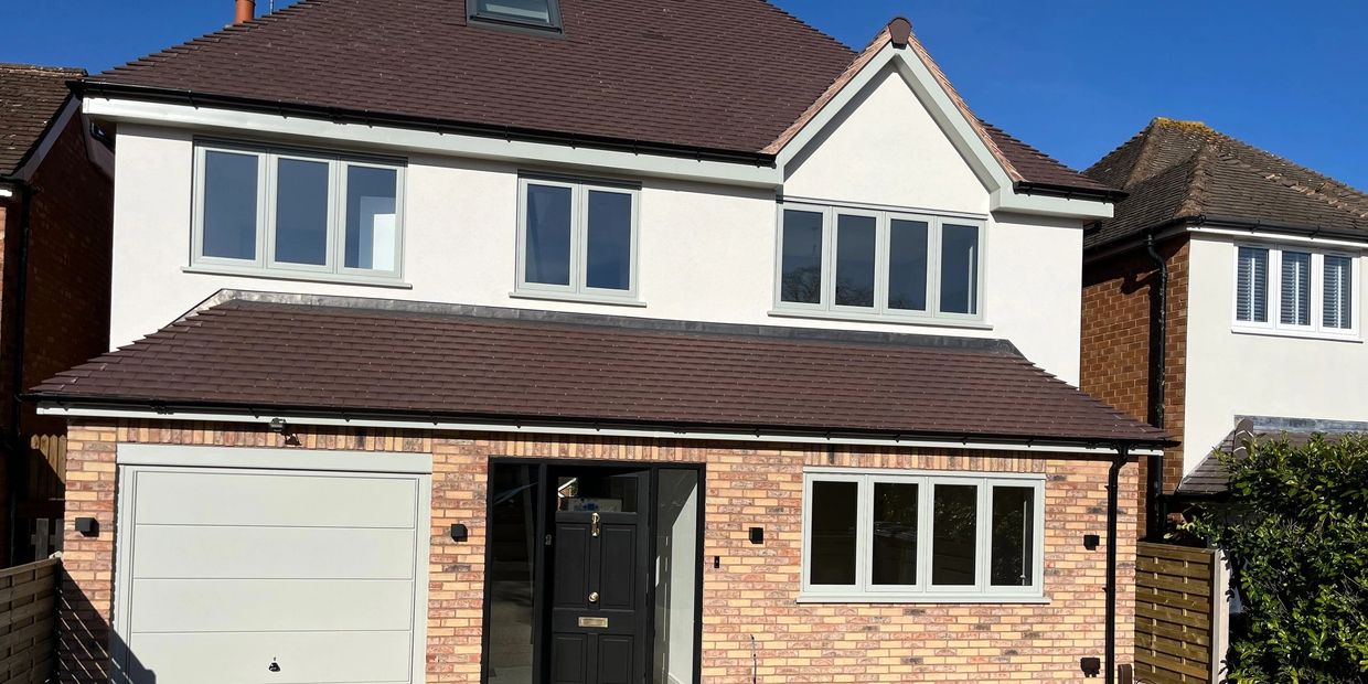 Front elevation of house with flush windows in sage green