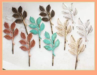 Colorful decorative leaf-shaped hairpins arranged in rows on a light background.
