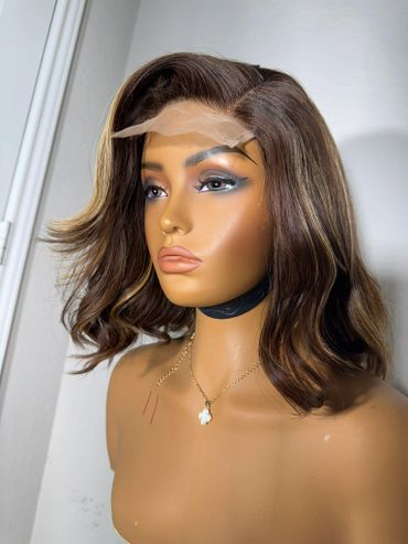 Mannequin head with styled brown wig and makeup, showing lace front.