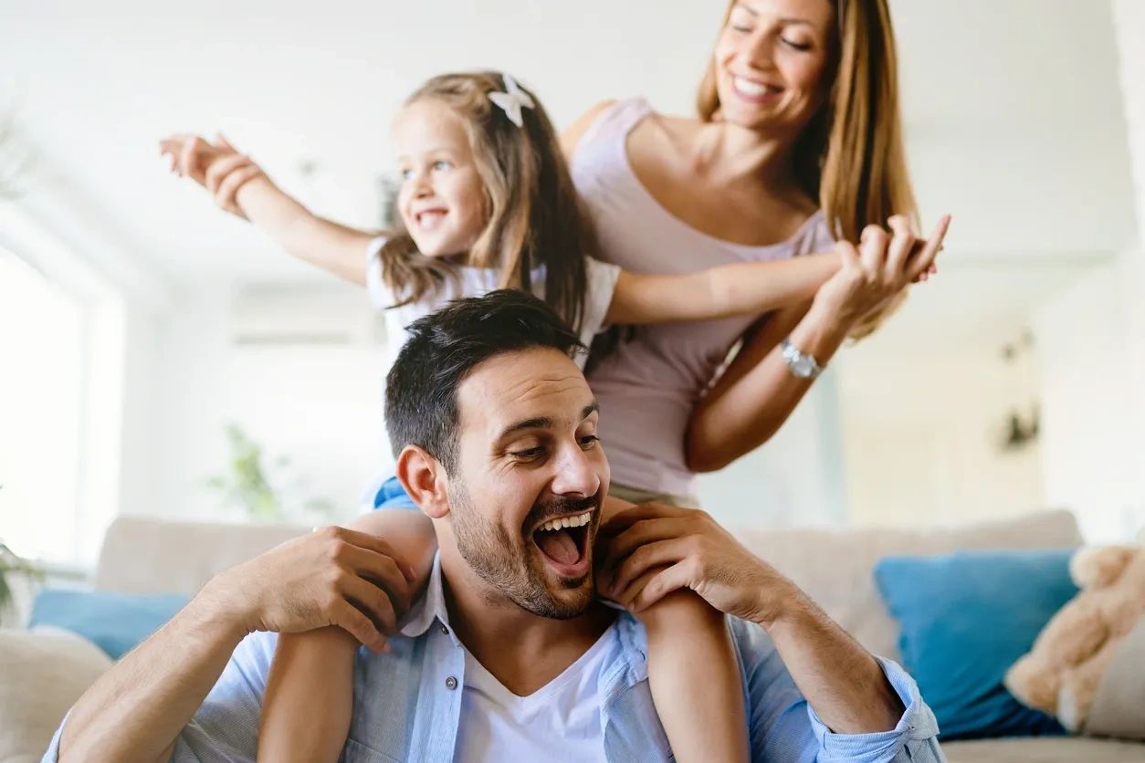 Happy family enjoying playful moments at home.