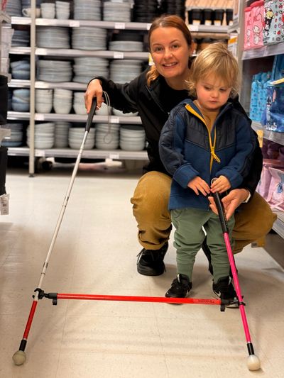 Courtney teaching cane skills to a little boy with the use of a tandem cane.