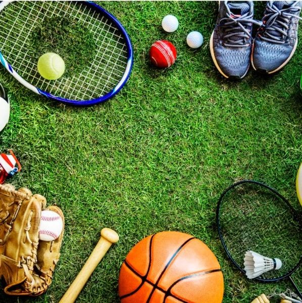 Various sports equipment arranged in a circle on grass.