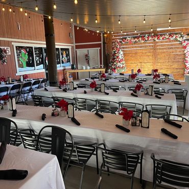 Indoor dining area decorated for Christmas with string lights and festive table settings.