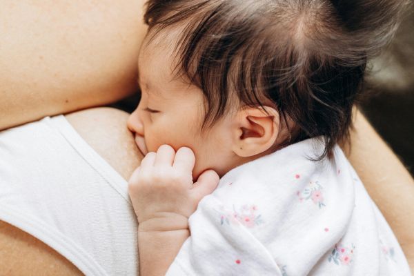 A baby nursing from mother wearing a nursing bra
