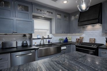 Appliance garage, custom range hood, stainless steel farmhouse sink, and honed slate counter tops.