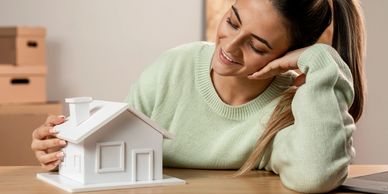 Woman admiring a small house model.
