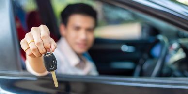 Man holding car key inside a car.