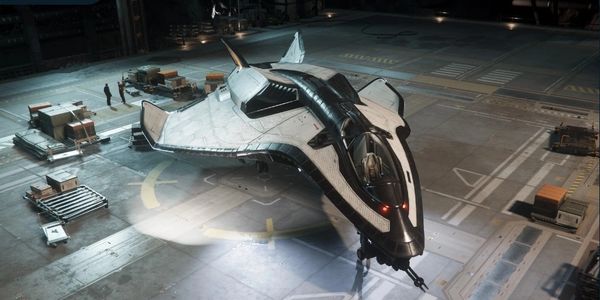 Futuristic spaceship docked in a hangar with personnel nearby.