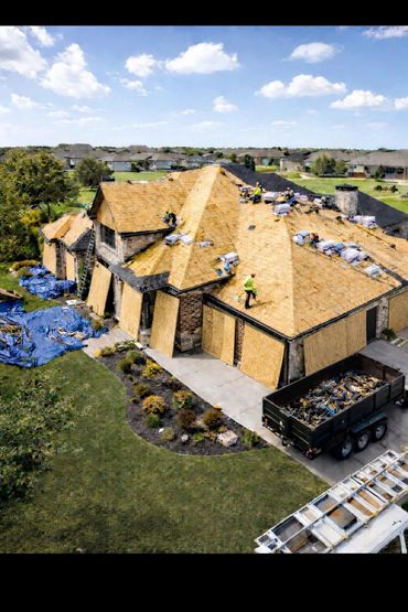 Workers replacing the roof after insurance claim approval
