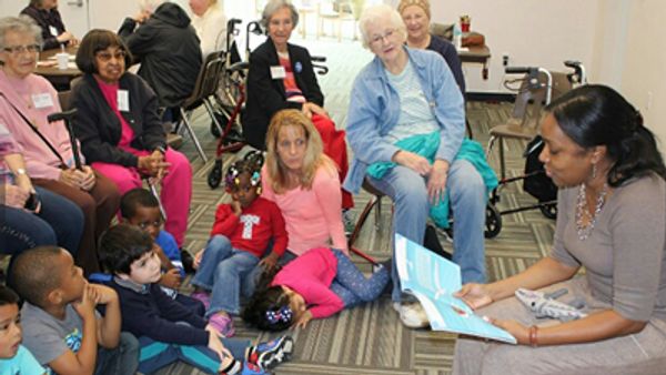 group of kids sitting together and listening to teacher
