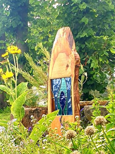English garden showing stained glass sculpture piece in cedar wood, set in a rural setting on the Bi