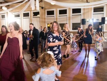 People joyfully dancing at an indoor celebration with elegant decor.