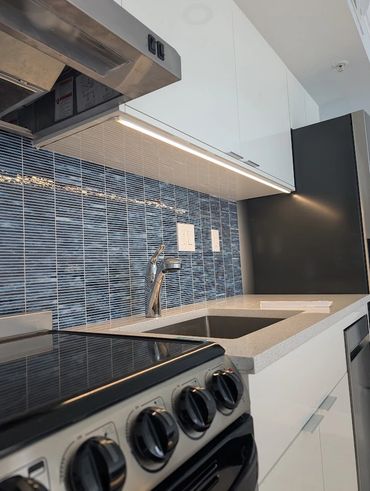 Nicely lit backsplash in small modern kitchen