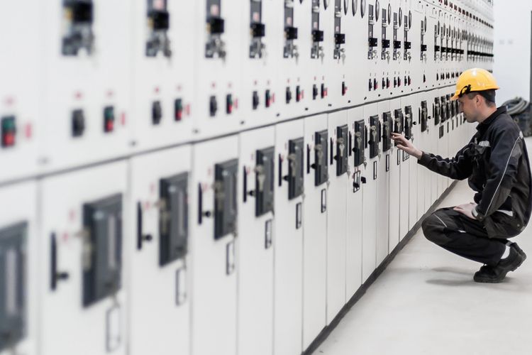 Stack of books next to pencils in a holder and a camera.