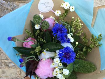 Posy bouquet with scented herbs, pink Peony and bright blue cornflowers.