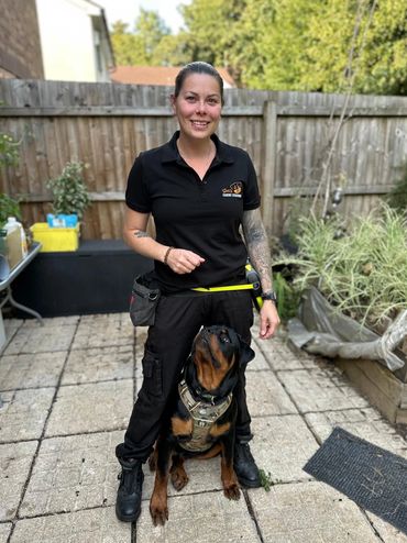 Dog trainer with her Rottweiler in a backyard setting.