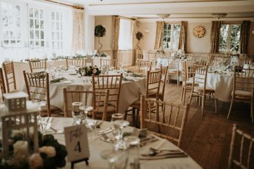 Elegantly set tables in a bright banquet hall.