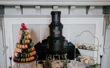 Black wedding cake with macaron tower and stand.