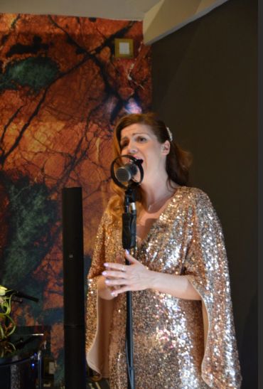 Woman singing passionately into a vintage microphone.