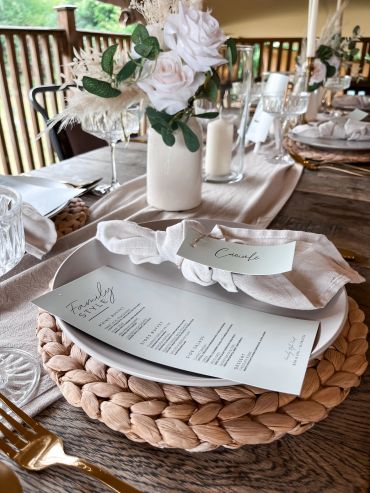 Elegant table setting with floral centerpiece and menu.