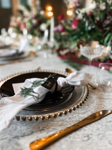 Elegant wedding table setting with gold accents and floral decor.