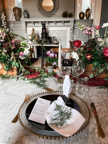 Elegant dining table setup with floral arrangements and a detailed menu.
