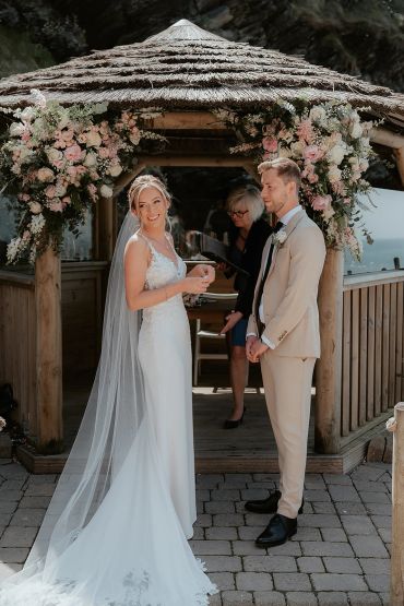 Bride and groom at wedding altar with floral decorations.