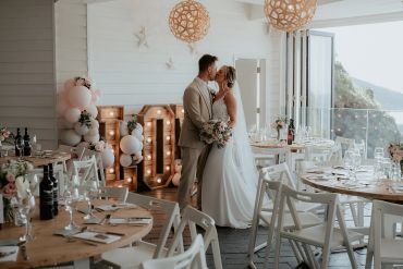 Bride and groom sharing a kiss at a wedding reception.