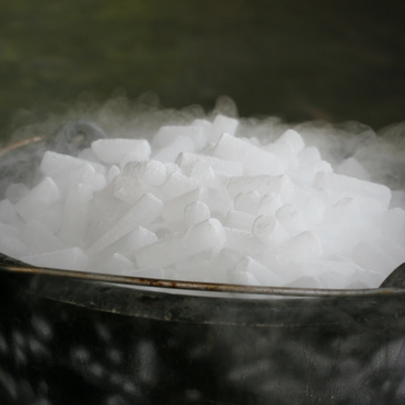 A bucket filled with dry ice emitting fog.