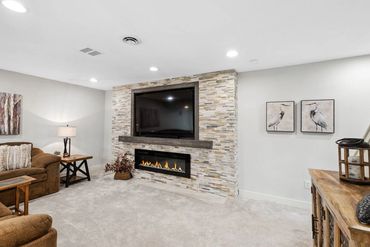 a living room with sofa, paintings, and TV