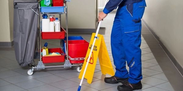 a person cleaning the floor with mop 