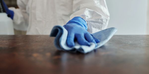 a person wearing gloves cleaning the table 
