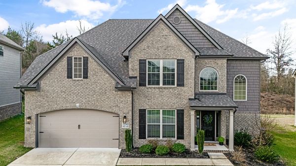 Modern two-story brick house with a double garage and landscaped front yard.