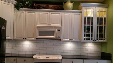 Modern kitchen with white cabinets, subway tile backsplash, and black countertops.