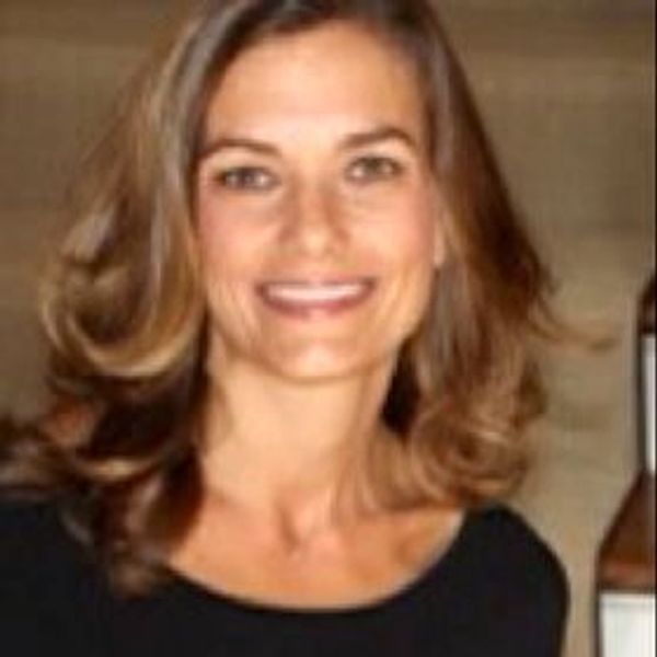 Smiling woman with shoulder-length hair in a black top.