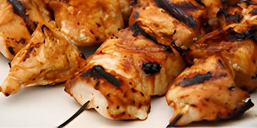 Close-up of grilled chicken pieces with visible char marks.