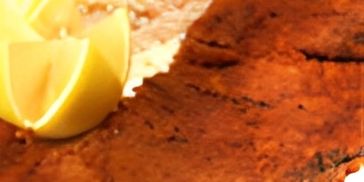 Crispy fried fish fillet with a lemon wedge and white rice.