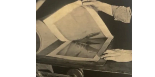 Hands holding and examining a printed photograph.