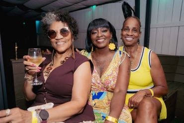 Three women smiling, enjoying a night out together.